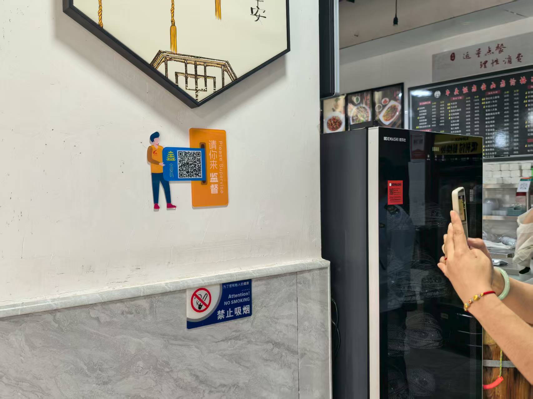 店主正在扫墙上的“金安码”。人民网记者 郝萍摄