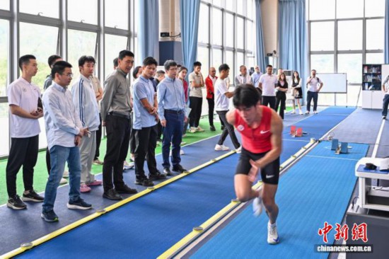 图为苏炳添在训练基地内了解数字化跑道分析系统。中新社记者 陈骥旻 摄