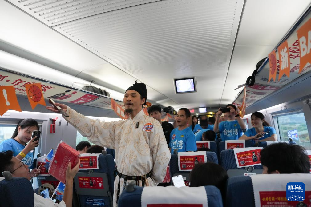 在杭台高铁“浙BA”球迷车厢内,“诗人李白”表演者与球迷旅客互动(9月10日摄)。新华社记者 黄宗治摄