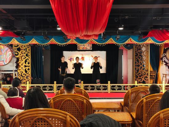 三位演出者正在向台下观众展示表演时用到的皮影。新华社记者 张申博 摄
