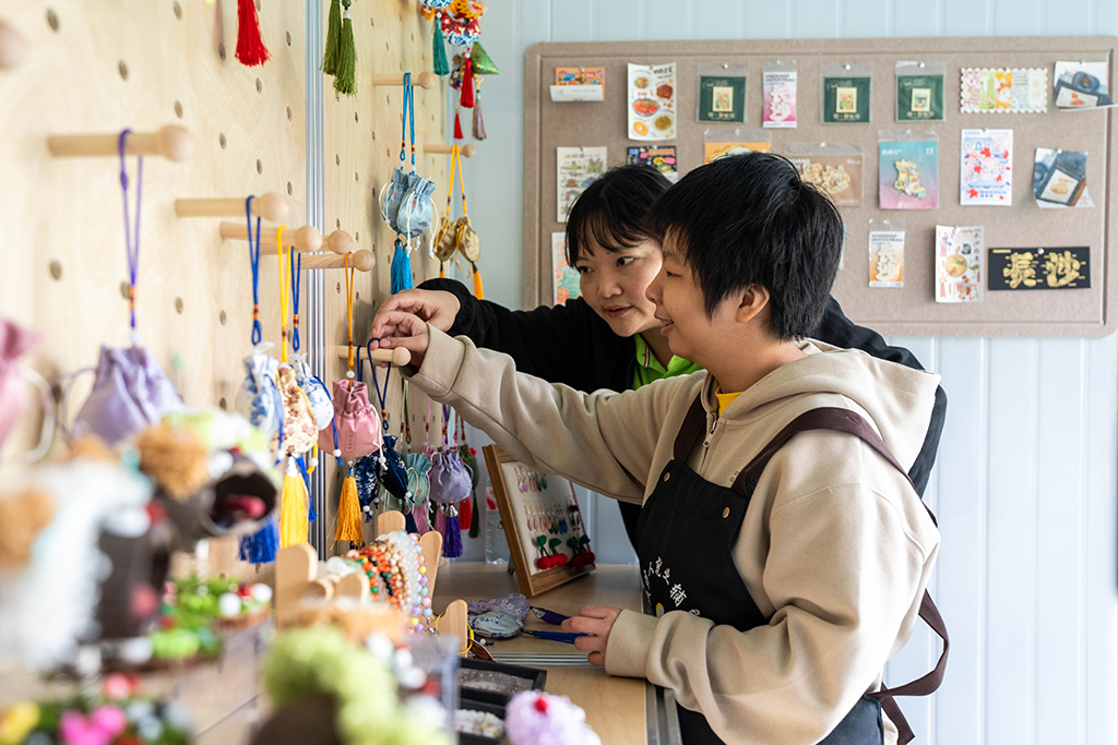 10月29日，在望城区星羽残疾人托养中心公益文创展销区，学员（右）在整理文创产品。