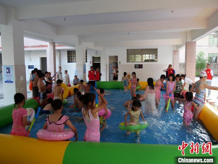 五里牌小学里,周边的孩子们在家长的陪同下玩水嬉戏。 王昊昊 摄 五里牌小学里,周边的孩子们在家长的陪同下玩水嬉戏。 王昊昊 摄