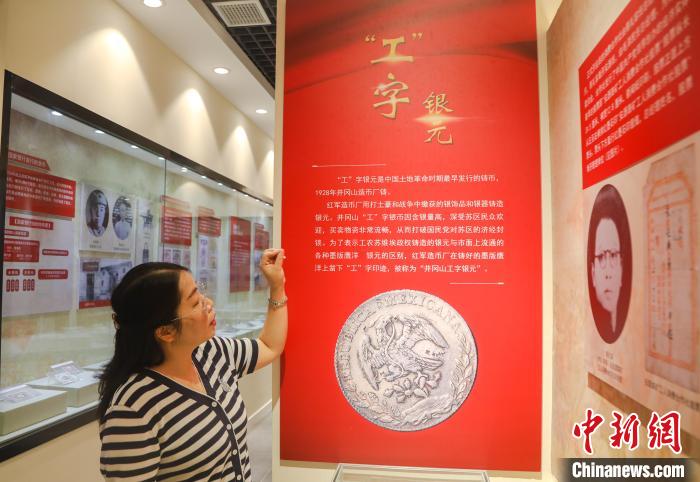 金花正在介绍“工”字银元。 刘力鑫 摄 金花正在介绍“工”字银元。 刘力鑫 摄
