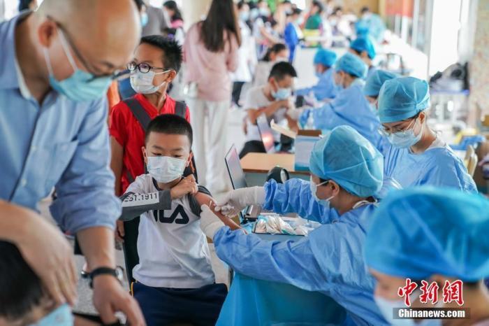 资料图：小学生在家长陪同下接种新冠疫苗。 <a target='_blank' href='/'>中新社</a>记者 陈冠言 摄
