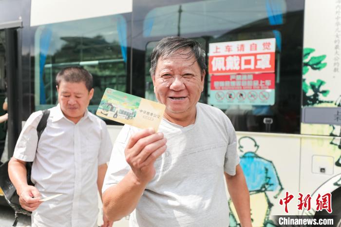 乘客体验“慈孝公交”活动,并拿到公交纪念车票。 主办方供图 乘客体验“慈孝公交”活动,并拿到公交纪念车票。 主办方供图