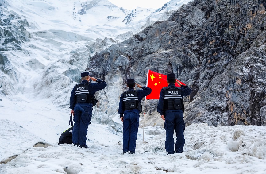 民警到达巡逻指定的地点后，向国旗进行敬礼。新疆出入境边防检查总站伊犁边境管理支队洪土沟边境检查站供图