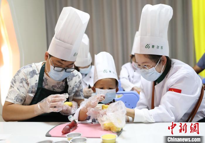 家长带着孩子在宁夏万杞园枸杞食品文化馆体验月饼DIY。　于晶 摄