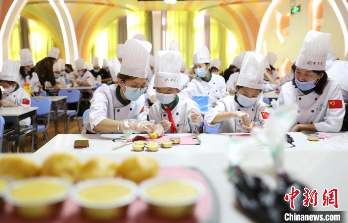 家长带着孩子在宁夏万杞园枸杞食品文化馆体验月饼DIY。　于晶 摄