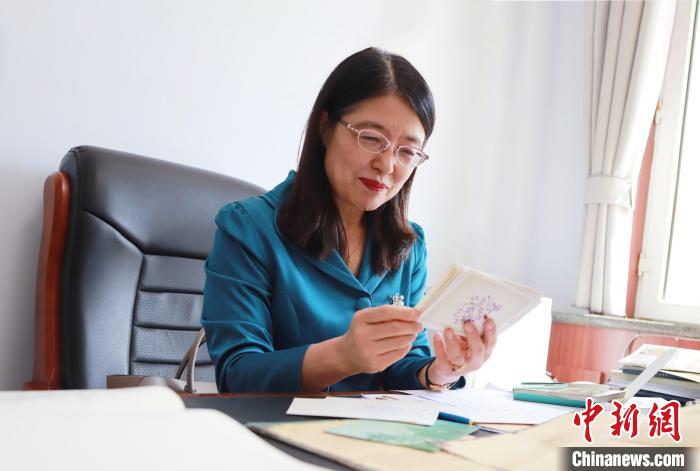 图为于秀娟读学生的赠言贺卡。 陈先达 摄 图为于秀娟读学生的赠言贺卡。 陈先达 摄