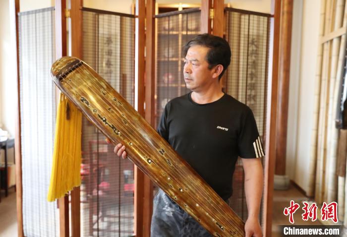 马光明在展示自己制作的古琴。 于晶 摄 马光明在展示自己制作的古琴。 于晶 摄
