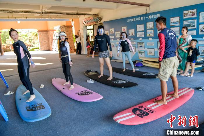 图为游客跟着冲浪教练学习冲浪技术要领。　骆云飞 摄