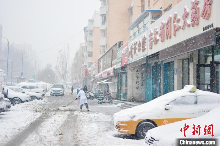 商家清扫门前积雪。　郭佳 摄