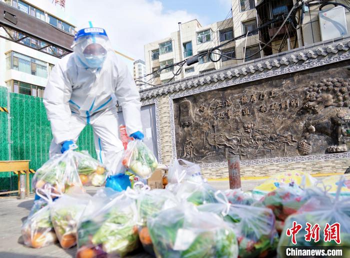 资料图为抗疫人员正在配送物资。　马铭言 摄