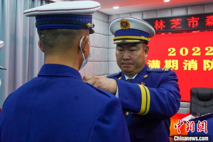 图为为退出消防员卸下肩章。　杨永龙 摄