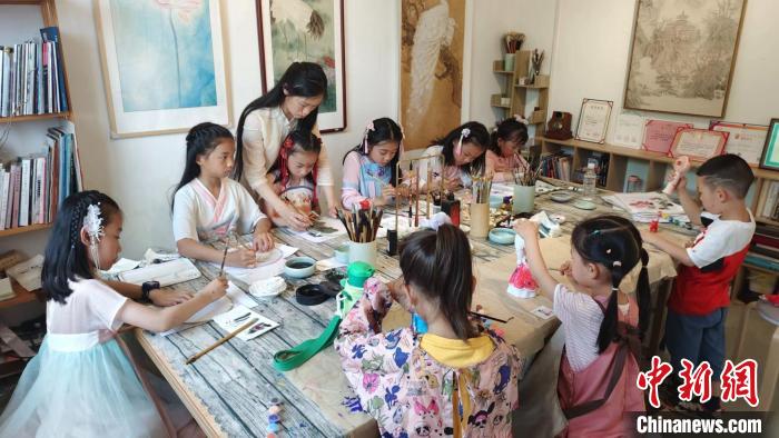 郦江渝妻子正在教小朋友学习绘画。　郦江渝 摄