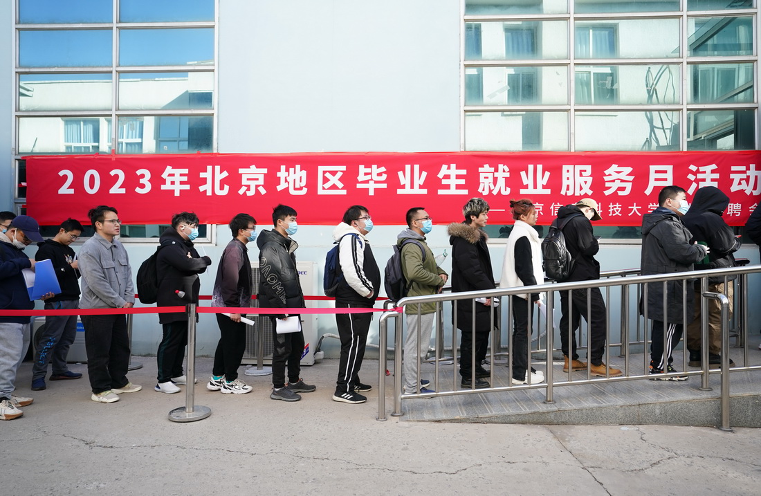 3月1日，在北京信息科技大学，求职学生排队等候进入招聘会现场。