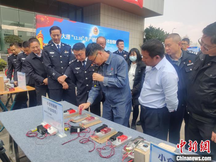 图为工作人员现场讲解涉案物资。　成洁焕 摄