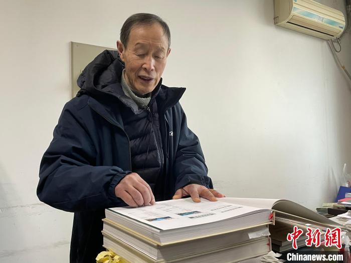 印开蒲翻看《百年变迁——两位东西方植物学家的影像重逢》。 祝欢 摄 印开蒲翻看《百年变迁——两位东西方植物学家的影像重逢》。 祝欢 摄