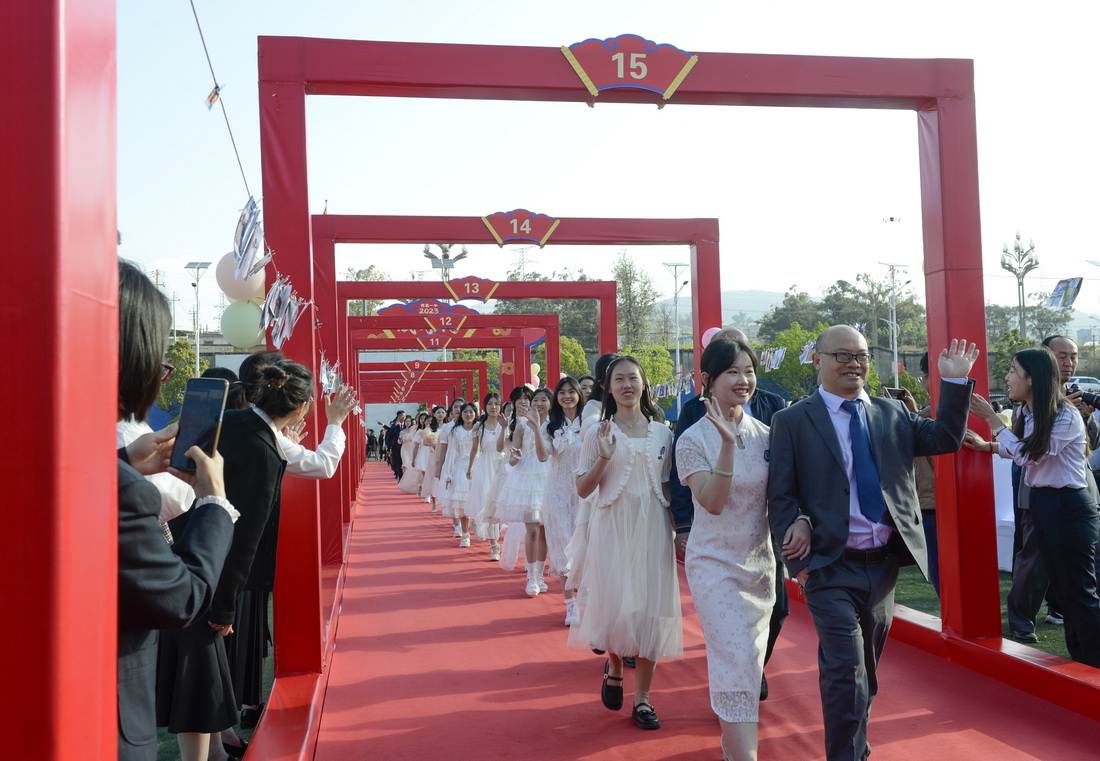 4月2日，在西昌一中成人礼上，家长带领学生走过“成人门”。