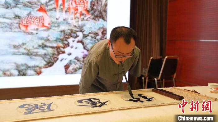 拍卖会上，无臂书法家现场创作书法作品。　中国残疾人福利基金会供图